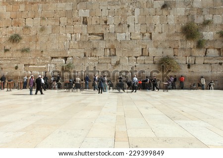 Jerusalem, Israel - November 9, 2014 : Local People and tourists pray at the western wall. The western wall is an exposed section of ancient wall situated on the western flank of the Temple Mount.