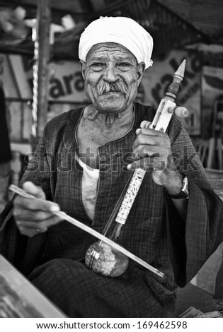 LUXOR, EGYPT - JULY 19, 2010: A musician perform outside tourist attractions on July 19, 2010 in Luxor, Egypt. Local entertainers frequently perform at local tourist attractions