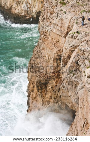 ALGARVE, PORTUGAL - JANUARY 24: Severe dramatic seascape with fisherman in Cape Saint Vicent cliffs on the Atlantic coast on January 24, 2009, Portugal