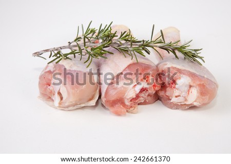 Chicken thighs or legs isolated over white background with a branch of rosemary plant