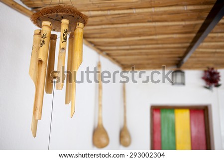 Hanging bamboo wind chimes and reggae color wooden door at the bottom