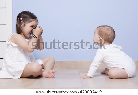 Image, Stock Photo brother taking a picture of his sister with mobile phone