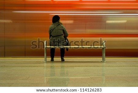 Young girls is waiting the subway in the station.