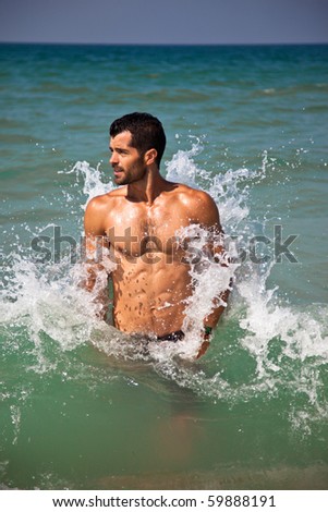 Muscular man playing with waves