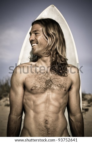 Attractive handsome muscular long haired surfer posing with his surfboard behind him. Metallic, cold feel.