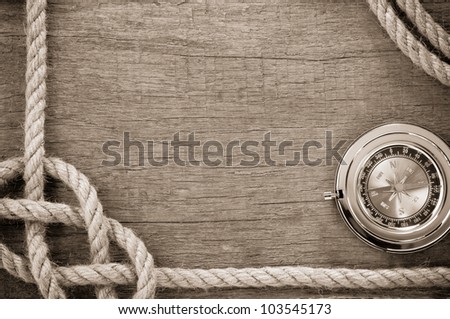 ship ropes and compass with pen on old vintage wooden background