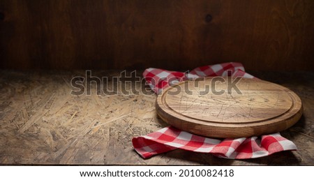 Pizza cutting board for homemade bread cooking or baking on table. Empty pizza board at wooden tabletop background. Bakery concept in kitchen