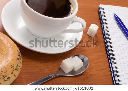 cup of coffee, pad and pen on table