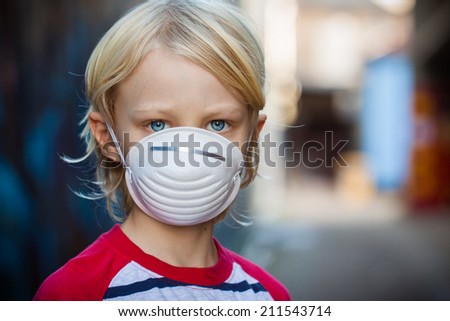 A worried child  wearing a protective face mask to prevent virus infection or pollution.