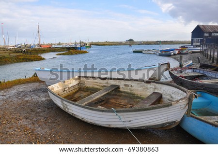 An old rowing boat drawn up on the shore of a sheltered harbour
