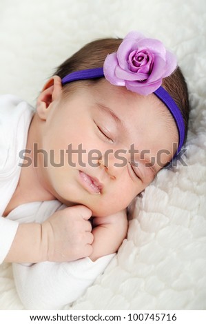Sleeping newborn wearing flower head band