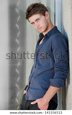 Happy young stylish man hands crossed looking in camera outdoors