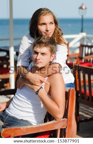 Happy young couple hugging each other at sea beach in summer outdoors