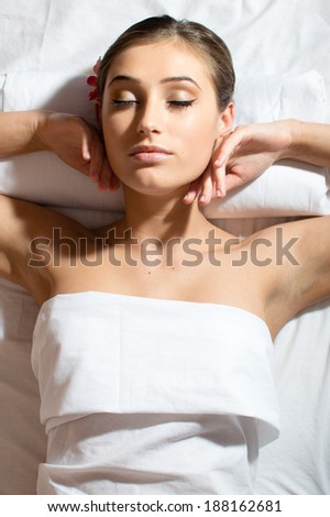 relaxed beautiful young woman lying on her back and getting beauty massage enjoying treatment picture