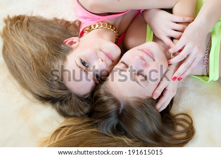 closeup picture of 2 best girl friends or sisters beautiful blond young women having fun in bed happy smiling one girl with eyes closed portrait
