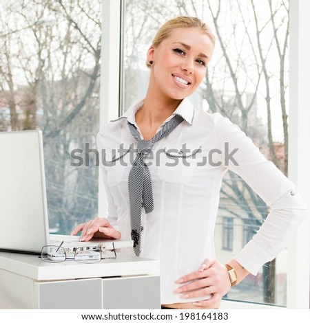 Portrait of happy young business woman blond girl using laptop notebook PC computer relaxing at office window copy space background having fun happy smiling and looking at camera picture