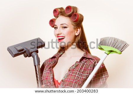 right choice: beautiful young blond pinup woman holding vacuum cleaner and brush looking in camera on white copy space background portrait picture