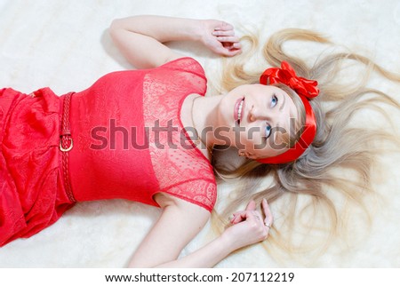 portrait of beautiful funny blond pinup girl in red dress having fun relaxing happy smiling & looking at copy space nicely over white background