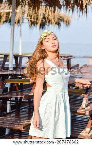sea beauty: stylish sexy pretty lady having fun relaxing on pier looking at camera on blue outdoors copy space background, portrait