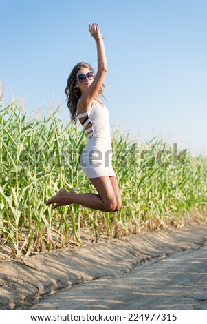 sexy pretty girl in white mini dress jumping high and happy smiling on blue sky outdoors copy space background portrait