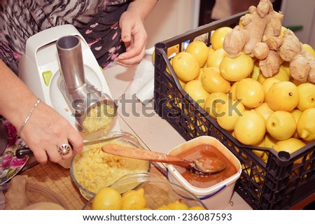 closeup image on woman hands making organic healthy food using lemon, honey, ginger & oil as ingredients