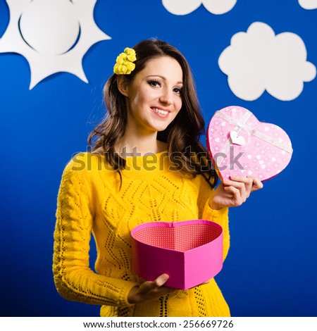Wonderful pretty girl in yellow sweater with open heart shaped present box