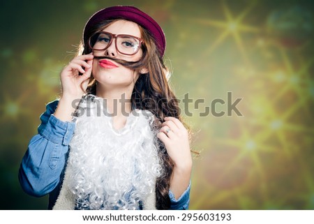 Using hair as mustache funny hipster beautiful young lady in super size eyeglasses wearing xmas santa hat and faux beard over copy space background