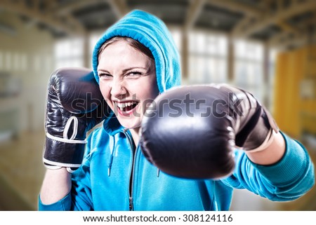 Confident excited sportsgirl in boxer gloves ready to fight