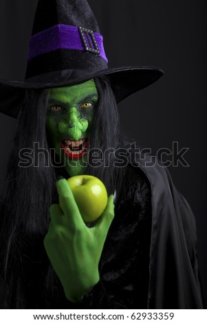 A Scary Witch Holding A Green Apple. Isolated On Black. Stock Photo ...