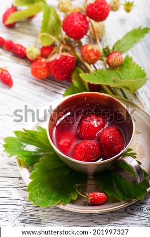 Wild strawberry jam in cup over white crackle texture