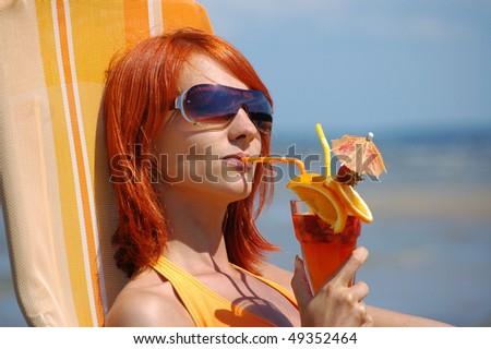 Young woman with cocktail on the beach