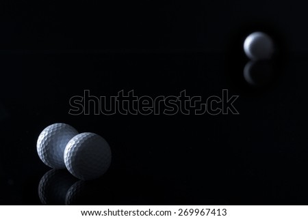 Few golf balls isolated on black background with empty copy space for text.