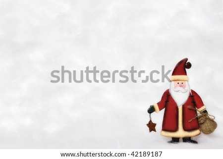 Cute Santa Claus figurine standing in snow, letter background