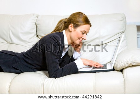 Young happy woman with  laptop on a couch