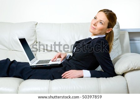Young business woman with laptop on sofa