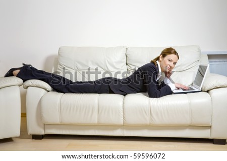 Young business woman with laptop on a couch