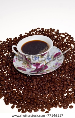 grains of the coffee with the cup of the hot coffee on the white background