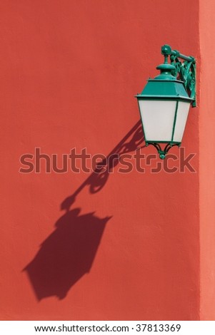 lamppost with shadow on a red wall