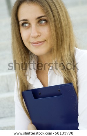 Attractive young businesswoman smiling with a folder on his chest