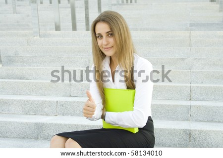 Business woman with a green folder. Presses the folder to her chest. Sign OK