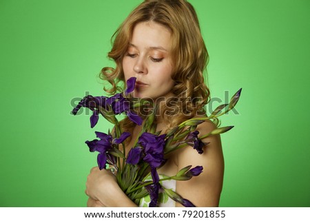 Happy close-up on a green background Happy young woman hugging a blue iris. Young Woman Hugging Flower