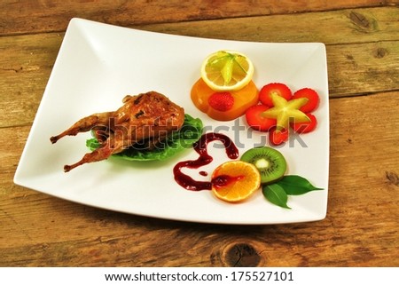 Quail on a bed of lettuce with fruit set