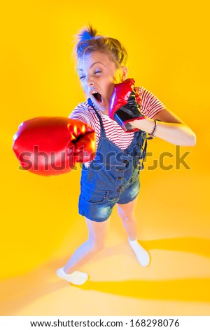 Funny fitness woman with boxing gloves, isolated on yellow
