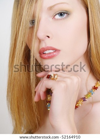 Portrait of beautiful young fashion model with long hair, jewelry