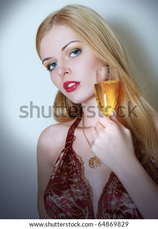 The beautiful young woman in an evening dress with a wine glass