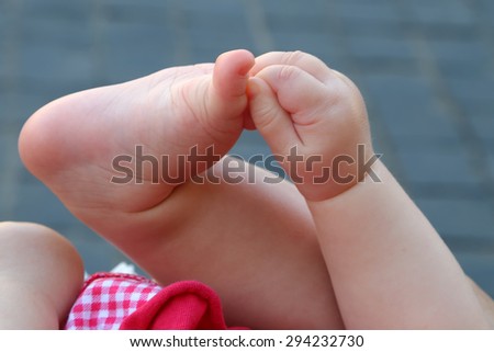 Newborn plays with hands and feet