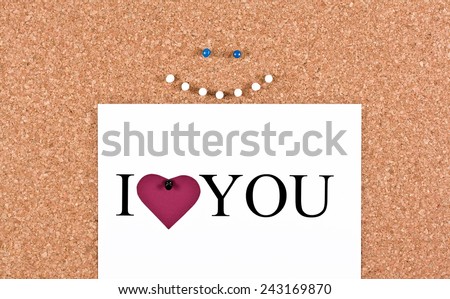 Cork board cheerful smiley face and a sheet with the words I love you
