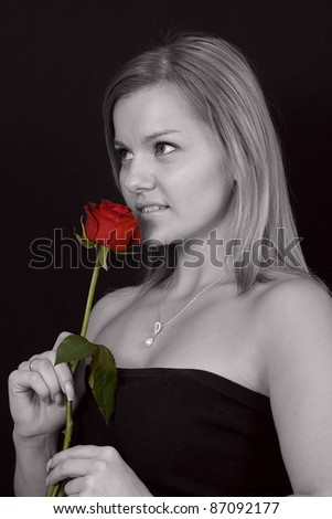 A profile of a pretty girl smelling rose in black and white with roses colored red