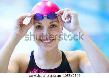 Portrait of a beautiful girl in a red cap at the swimming pool