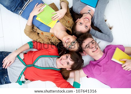 group of teenage friends look up at the camera with bright smiles
